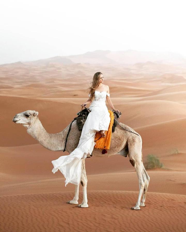 Hotel Sahara Majestic Luxury Camp Merzouga Exteriér fotografie A woman riding a camel in the desert